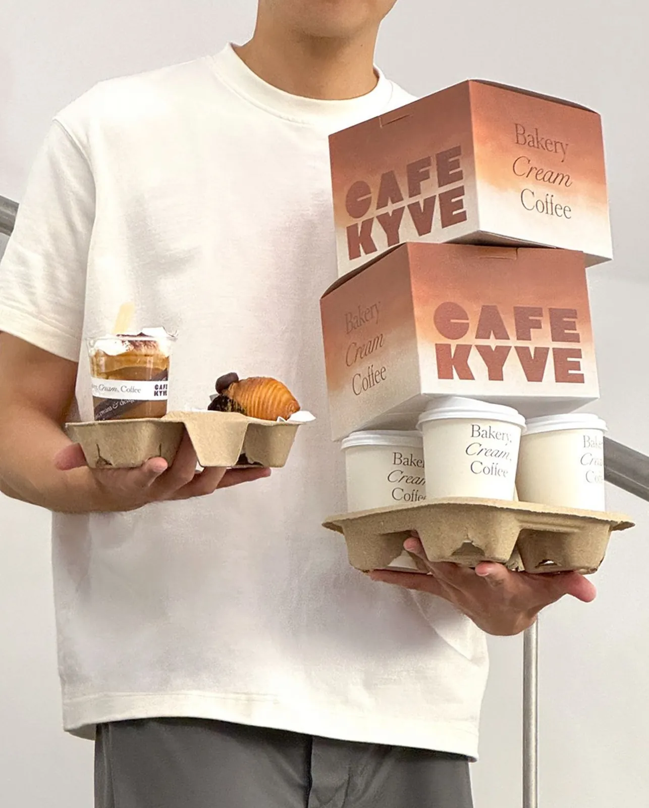 Person holding cafe takeaway trays
